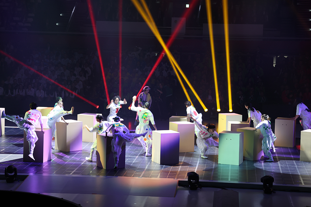 人が入れるほど大きな四角い箱のまわりで白地の衣装で踊っています