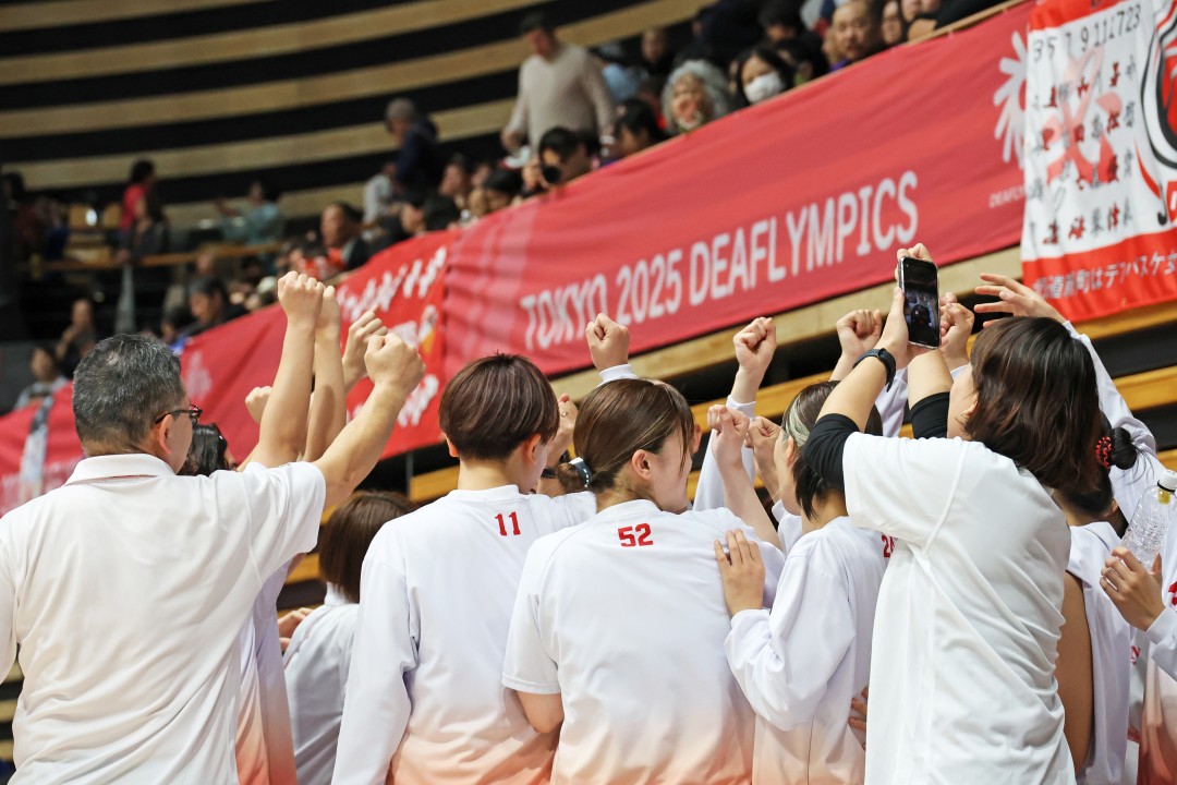 コート内に集まり、手をグーにして掲げる選手たち