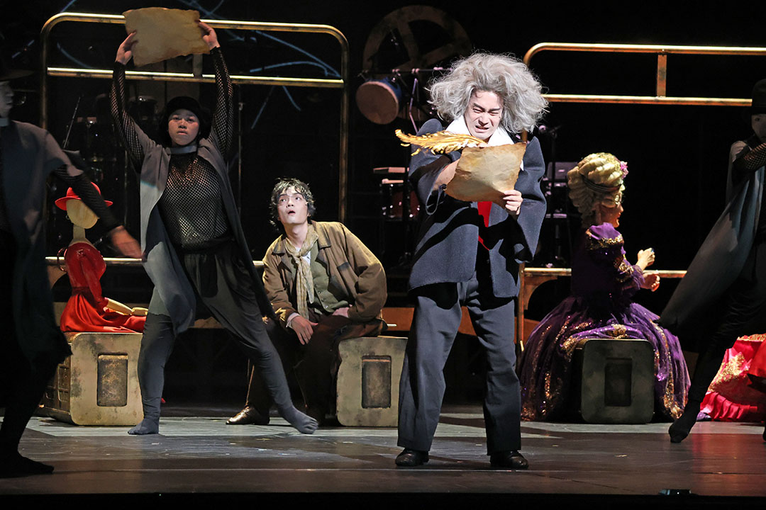 白髪の老人が紙に何かをかいています