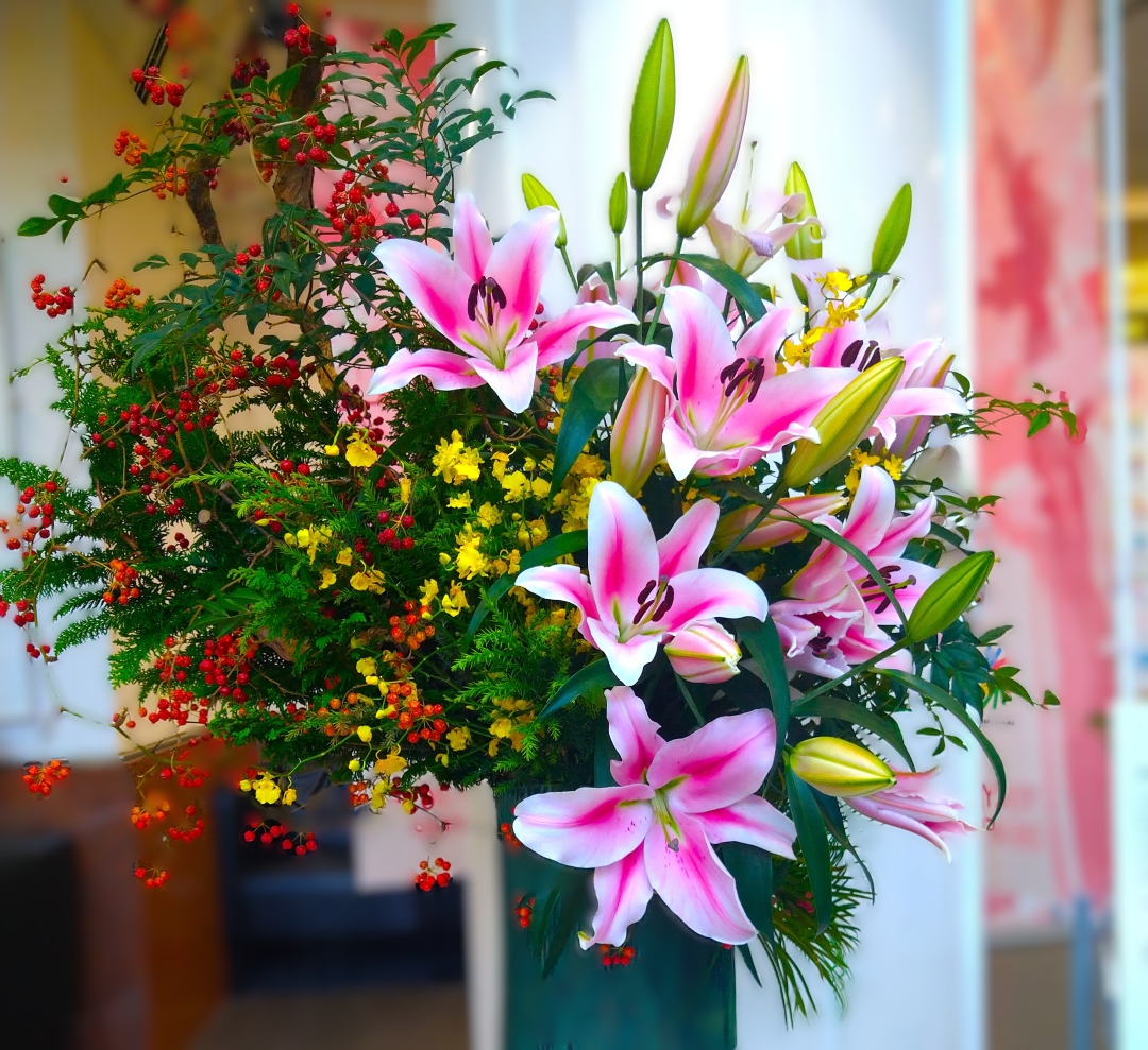デフリンピックスクエア―のロビーに置かれた赤いユリと赤い実の千両