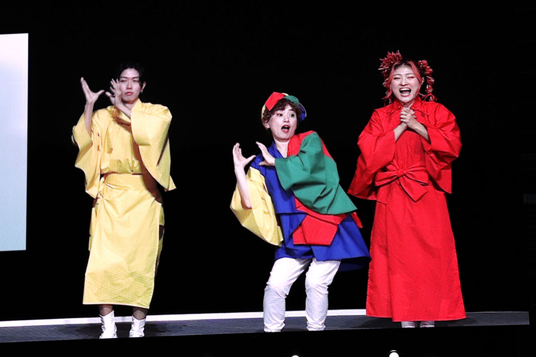 ステージで踊りの振り付けを指導する3人