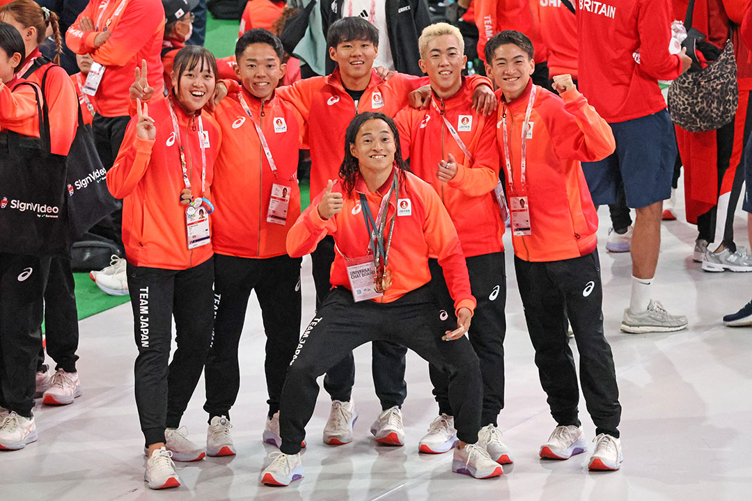 手前の陸上の選手を囲んで6人でならんでいます