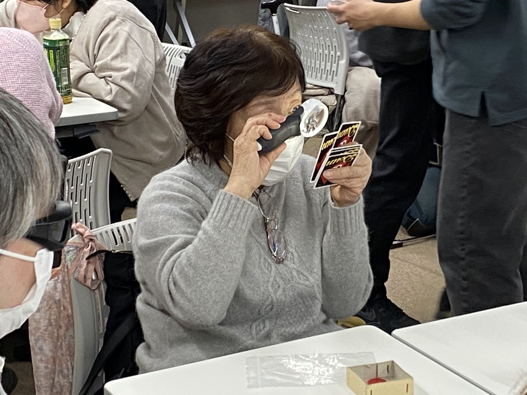 ルーペを使ってカードを見る参加者