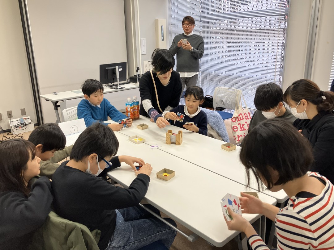 テーブルの手前には、手で触って点字を読んでいる子が二人、テーブルの向こうには目で見てカードを出している子が二人いる