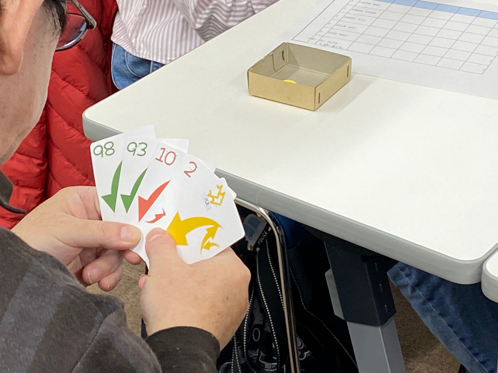 左上に点字が書かれたトランプを扇状に手に持っている参加者の手元