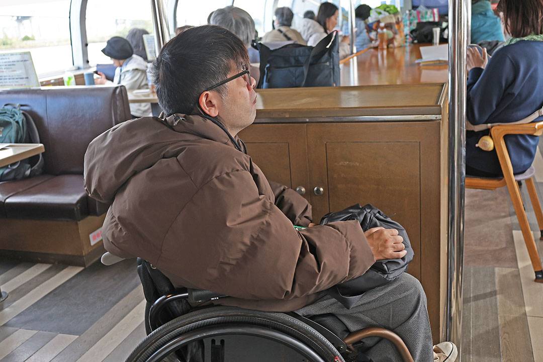 車いすスタッフが船内から景色を見ている様子