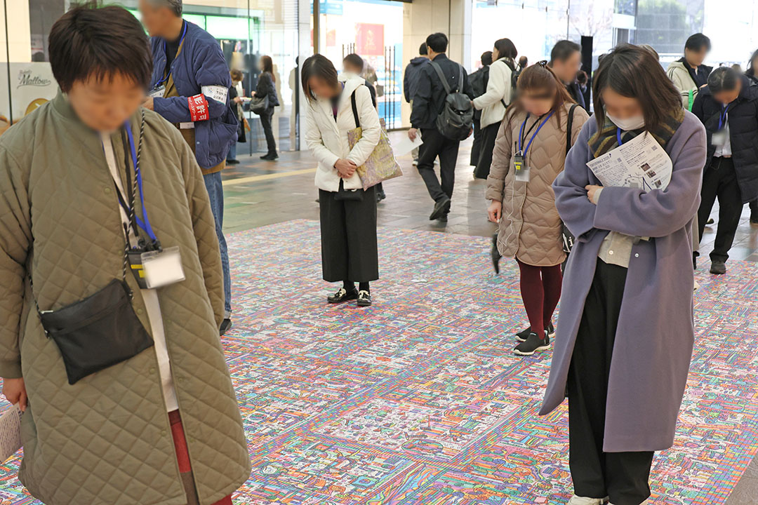 東京駅八重洲北口通路に設置された与那覇俊氏の作品を眺める参加者2