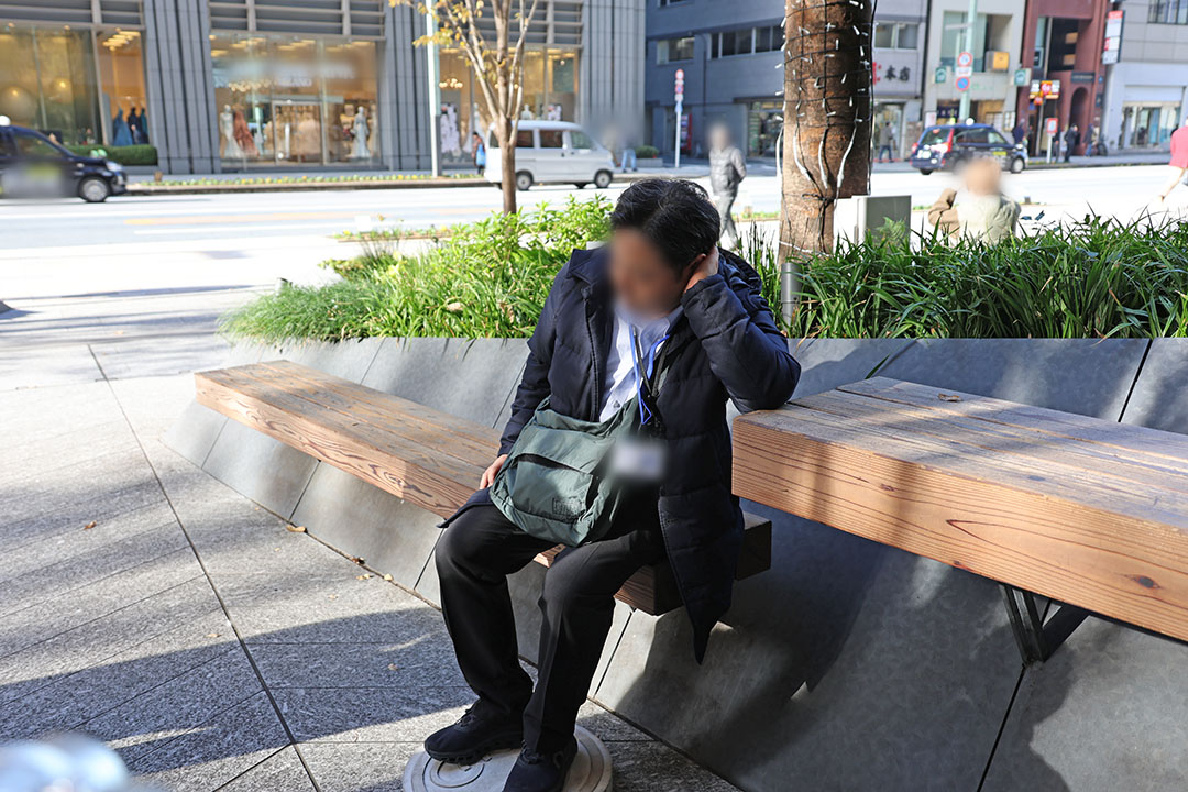 点音に」足を乗せ目を閉じて街の音に耳を傾ける男性